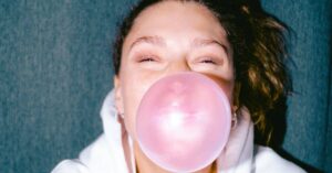 woman popping bubble gum on her mouth